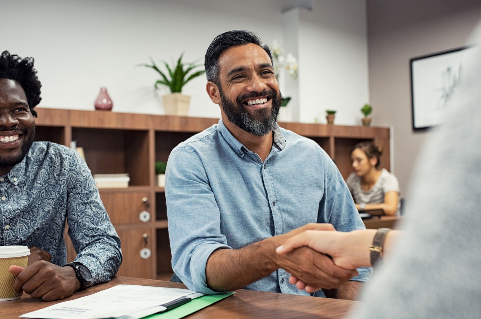 Smiling client shaking hands across a table